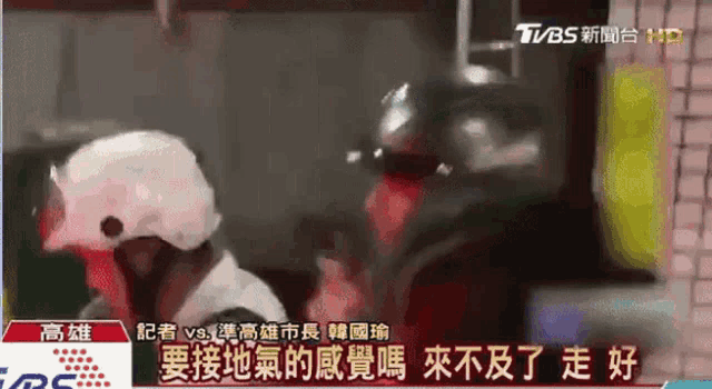a tv screen shows a man wearing a white helmet with chinese writing on it