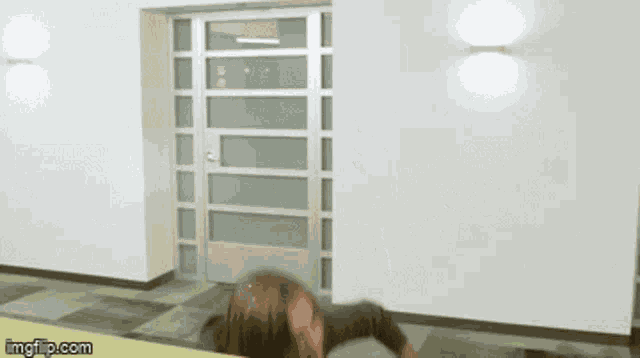 a man with long hair is standing in front of a door with imgflip.com written below him
