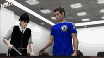 a man in a blue chelsea shirt talks to a policeman