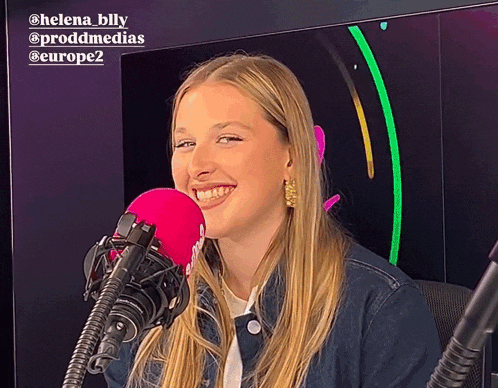 a woman is smiling in front of a pink microphone with the name helena billy on the top