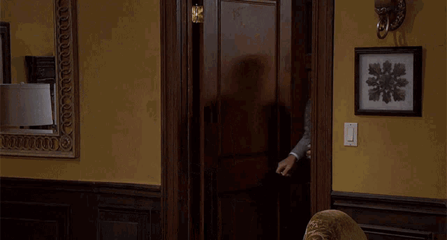 a man in a suit is holding a woman 's hand in a room