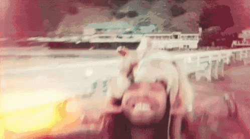 a blurry picture of a woman laying on her back on the beach .