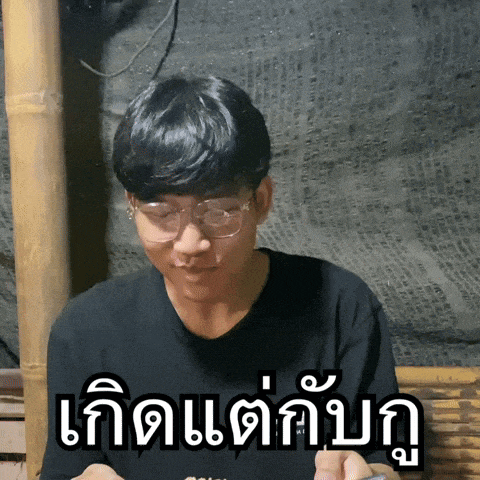 a man wearing glasses and a black shirt has a foreign language sticker on his chest