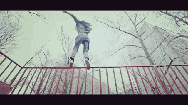 a person is jumping over a railing in the air
