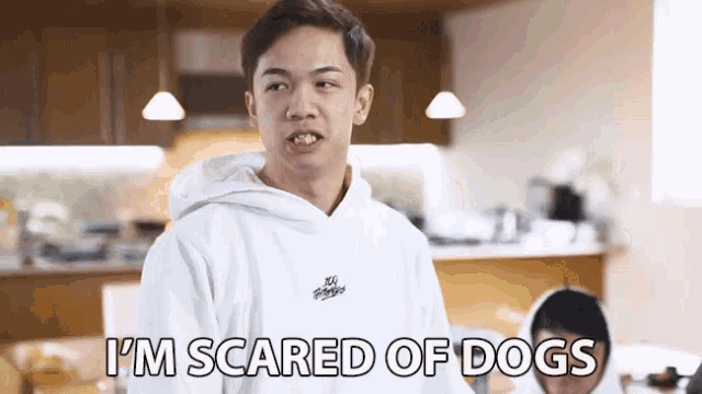 a man in a white hoodie says that he is scared of dogs
