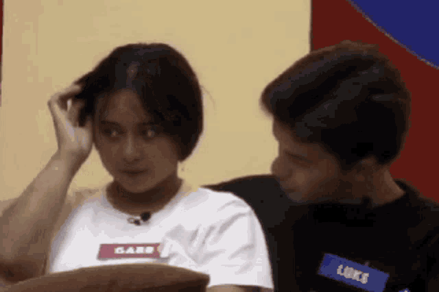 a man and a woman are looking at each other and the woman has a name tag that says luke