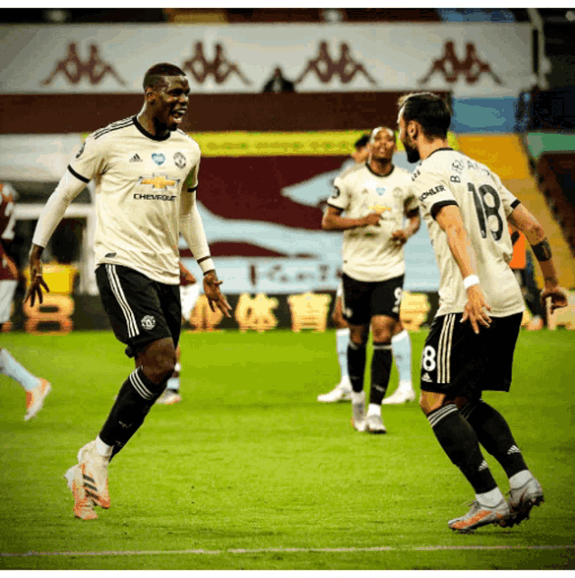 a soccer player with the number 18 on his jersey celebrates with another player