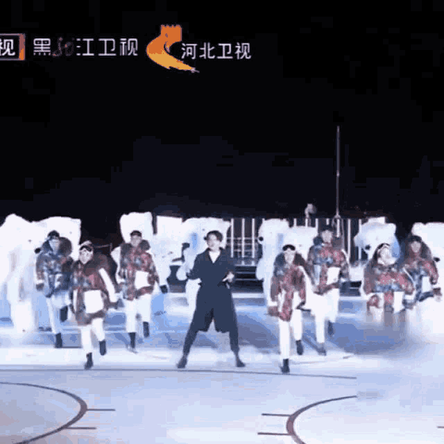 a group of people are performing on a stage with a fox logo in the background