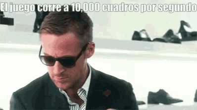 a man wearing sunglasses and a suit is looking at his phone in a store .