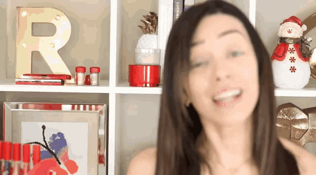a woman stands in front of a shelf that has a letter r on it