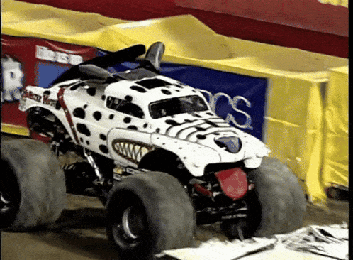 a monster truck that looks like a dalmatian is on a track