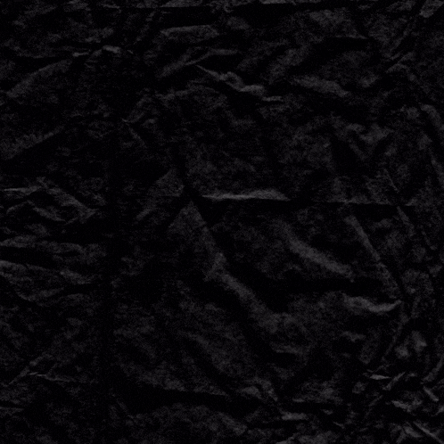 a crumpled piece of black paper with a white cross in the middle