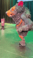 a stuffed animal is standing in front of a podium with a sign that says ' a ' on it