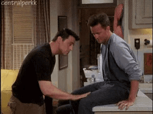 two men are standing next to each other in a kitchen .
