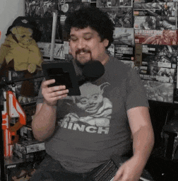 a man wearing a shirt that says minch is holding a tablet