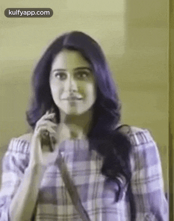 a woman is talking on a cell phone while standing in front of a mirror .