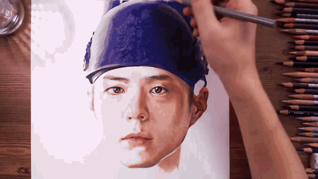 a person is drawing a portrait of a man wearing a blue headband