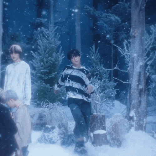 a man in a black and white striped sweater stands in the snow