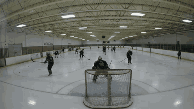 a hockey rink with a sign that says visitors on the wall