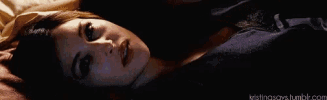 a woman in a black bra is laying next to a man