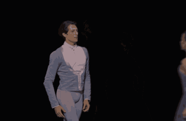 a man and a woman are looking at each other on a stage