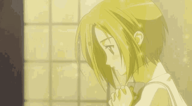 a girl with short blonde hair is holding her hand to her face