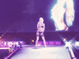 a woman is dancing on a stage in front of a large screen with a w logo on it