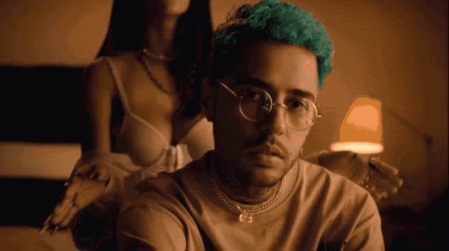 a man with green hair is sitting in front of a woman in lingerie