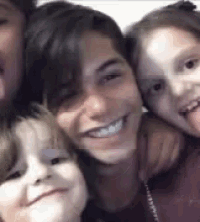 a woman and two children are posing for a picture together .