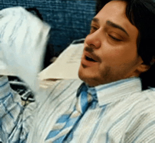 a man wearing a striped shirt and tie yawning