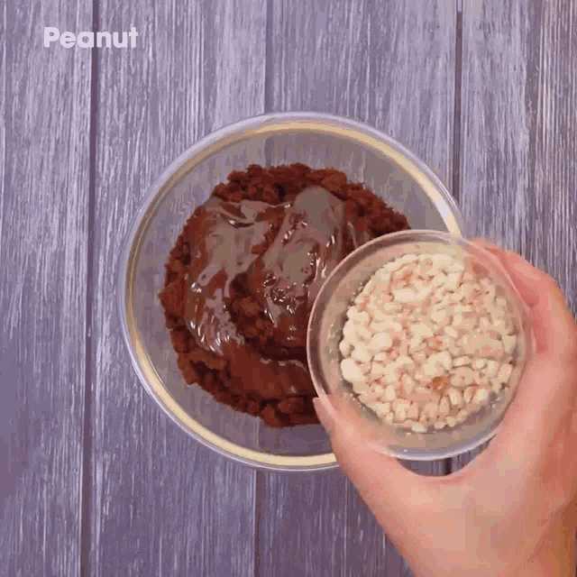 a person is pouring peanut butter into a bowl of chocolate