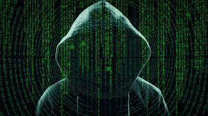a hacker in a hooded sweatshirt is standing in front of a green matrix background .