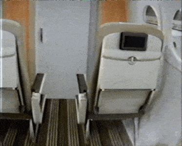 a row of empty seats on an airplane with a monitor on the back