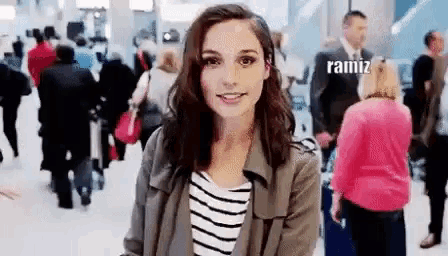 a woman in a striped shirt is standing in front of a crowd of people .