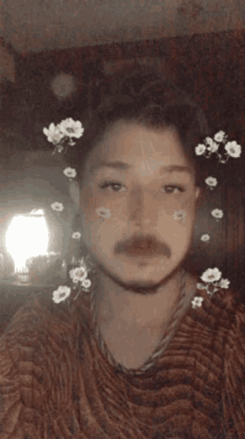 a man with flowers on his face is wearing a brown sweater