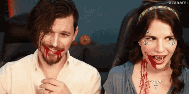 a man and a woman with blood on their faces are sitting next to each other and the woman has blood on her face