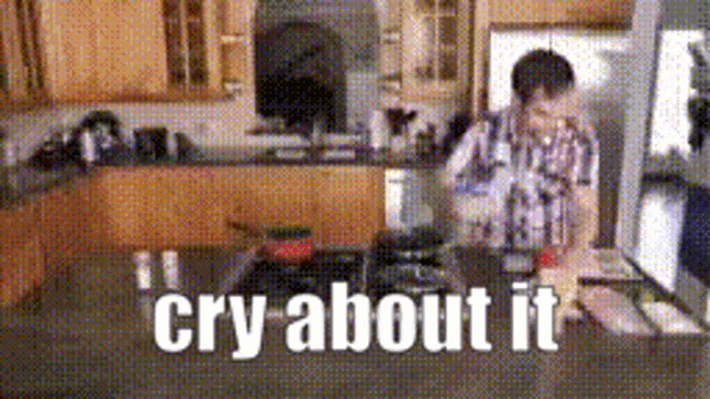a man is cooking in a kitchen and the words cry about it are on the counter