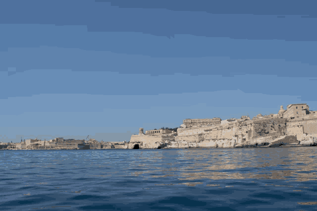 a large body of water surrounded by buildings and a blue sky