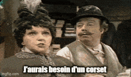 a man and a woman are standing next to each other in a room . the man is wearing a hat .