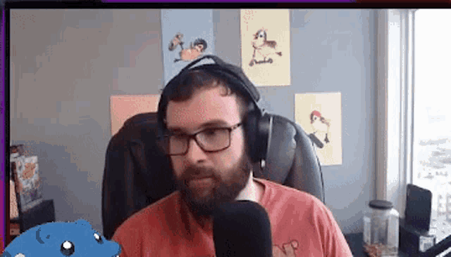 a man wearing glasses and headphones is sitting in front of a microphone in front of a window
