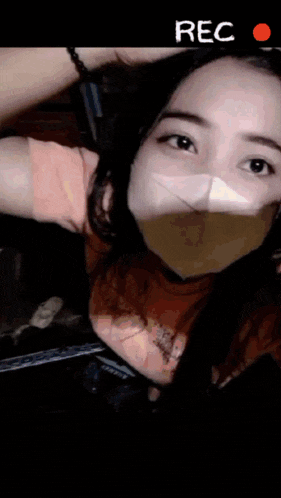 a woman wearing a face mask is being recorded on a device