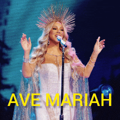 a woman in a white dress singing into a microphone with the words ave mariah behind her