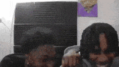 a couple of people are sitting next to each other in a room and laughing .