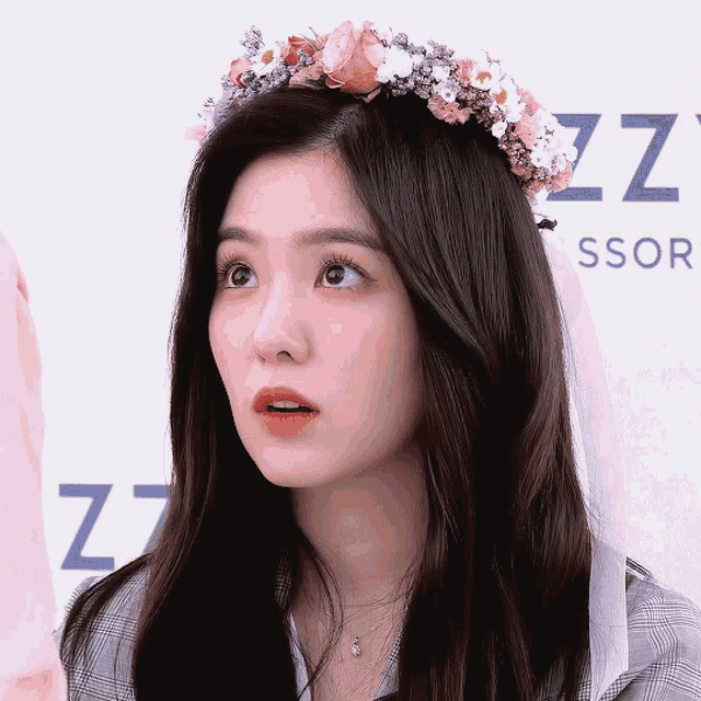 a woman wearing a flower crown stands in front of a sign that says zzz
