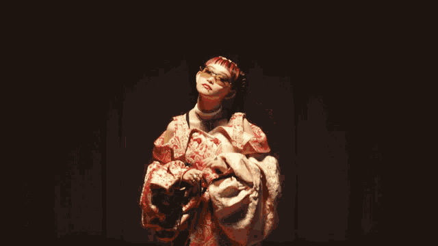 a woman with red hair is wearing a kimono and sunglasses