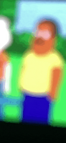a blurry picture of a man with a yellow shirt and blue shorts
