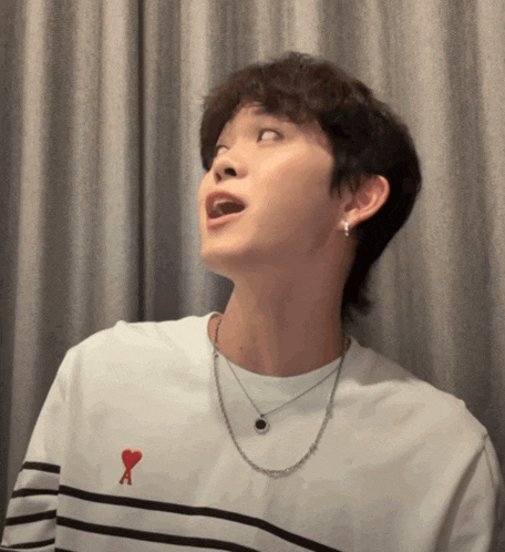 a young man wearing a striped shirt with a red heart on the chest