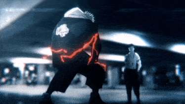 a man with a red lightning bolt on his back stands next to another man