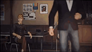a man in a suit is standing next to a woman sitting in a chair
