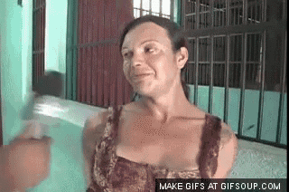 a woman in a leopard print dress is making a funny face while standing in front of a fence .